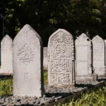 Intricately carved tombstones in Bursa's Ottoman cemetery with Arabic calligraphy.