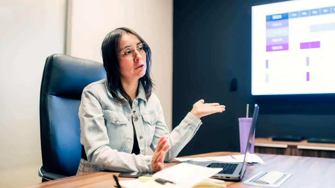 Woman gestures while explaining something at a presentation.