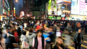 a crowd of people crossing a street at night