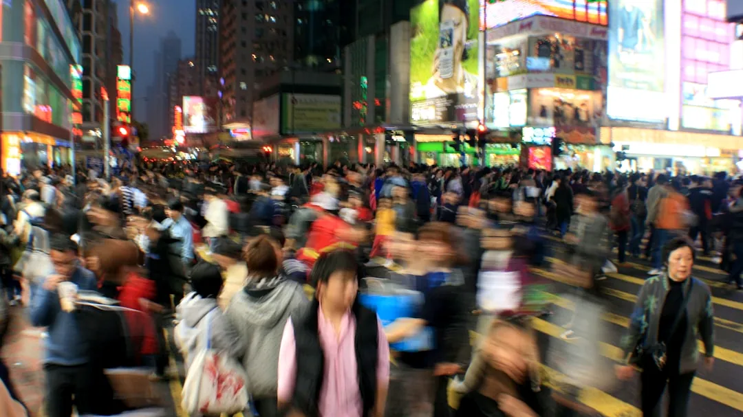 a crowd of people crossing a street at night
