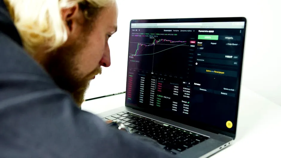 A focused man analyzing stock market data on a laptop, tracking investments and trading strategies.