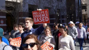 A group of people walking down a street holding signs