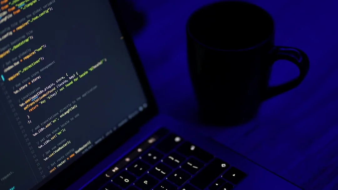 black laptop computer turned on beside black ceramic mug