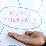 Close-up of a hand gesturing at a cryptocurrency diagram on a whiteboard, highlighting crypto concepts.