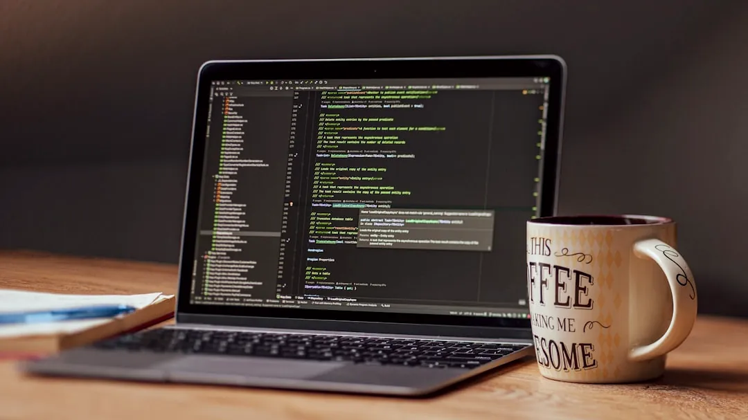 Laptop displaying code with a coffee mug nearby.