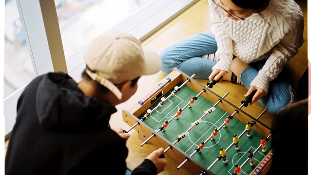 man and woman playing foosball table
