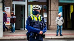 man in blue jacket wearing yellow helmet and yellow helmet standing on sidewalk during daytime