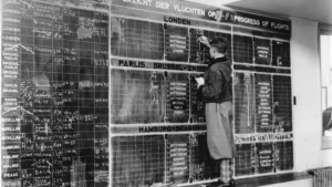 Man updates flight departure board with chalk