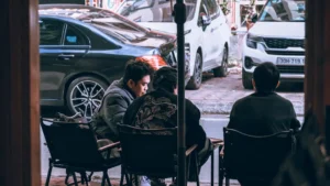 People sitting at tables outside a cafe.