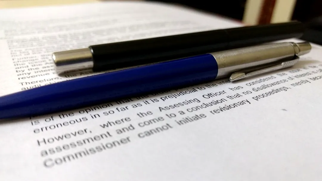 two black and blue click pens on white book page