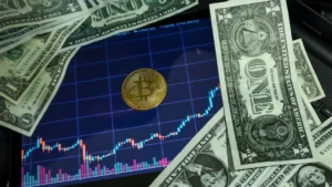 Bitcoin coin on a tablet showing stock chart, surrounded by dollar bills.