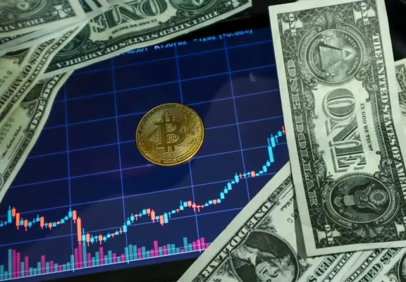 Bitcoin coin on a tablet showing stock chart, surrounded by dollar bills.