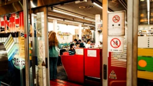 People inside a store with a red counter.